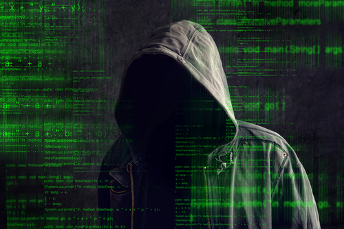 Man in Hoodie with Face Shrouded with Computer Code Superimposed
